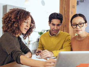 Three people looking at a computer screen