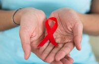 HIV ribbon on the hands of a female
