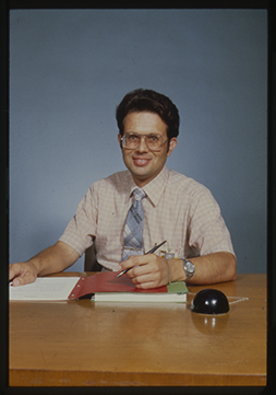 Color portrait of Dominick Cirincione sitting at a desk, dated 1982