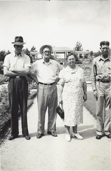 Four people standing in the Rose Gardens at the Fort Worth Botanical Gardens.