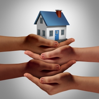 Diverse hands holding a house