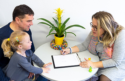 Image of a father and a daughter talking to a counselor