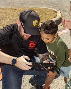 Officer and child looking at a drone controller