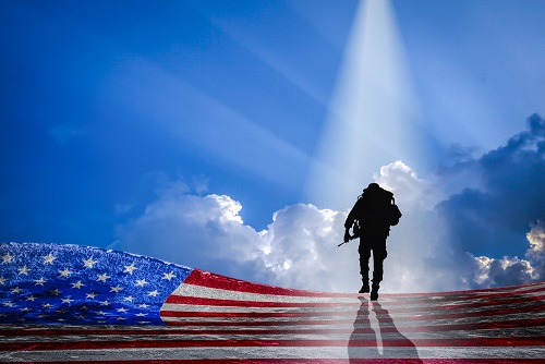 Soldier walking and an American flag