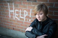 Girl in front of help graffiti