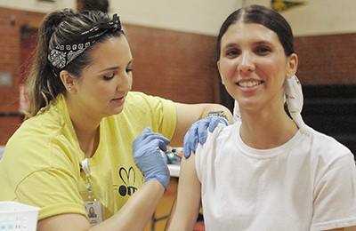 nurse vaccinating young woman