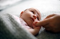 newborn holding mother's finger