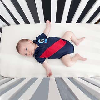 Baby in a crib laying on his back 