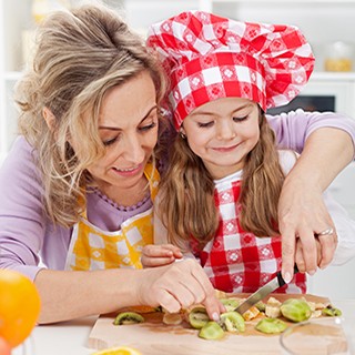Woman and little girl slicing fruit