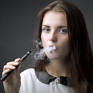 young woman holding e-cigarette, vaping