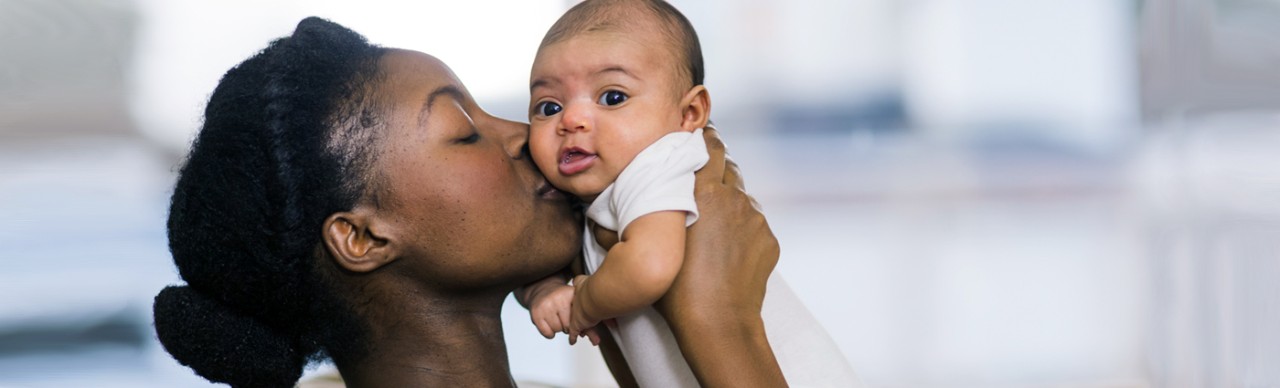 young back mother kissing baby