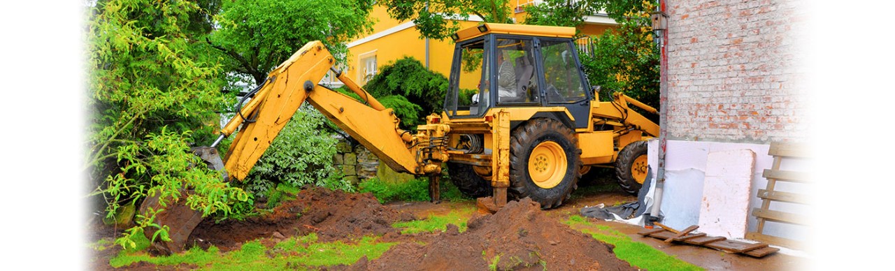 babkhoe tractor dgging in a yard