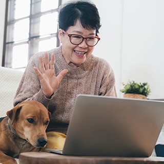 Asian elderly woman making video call on laptop